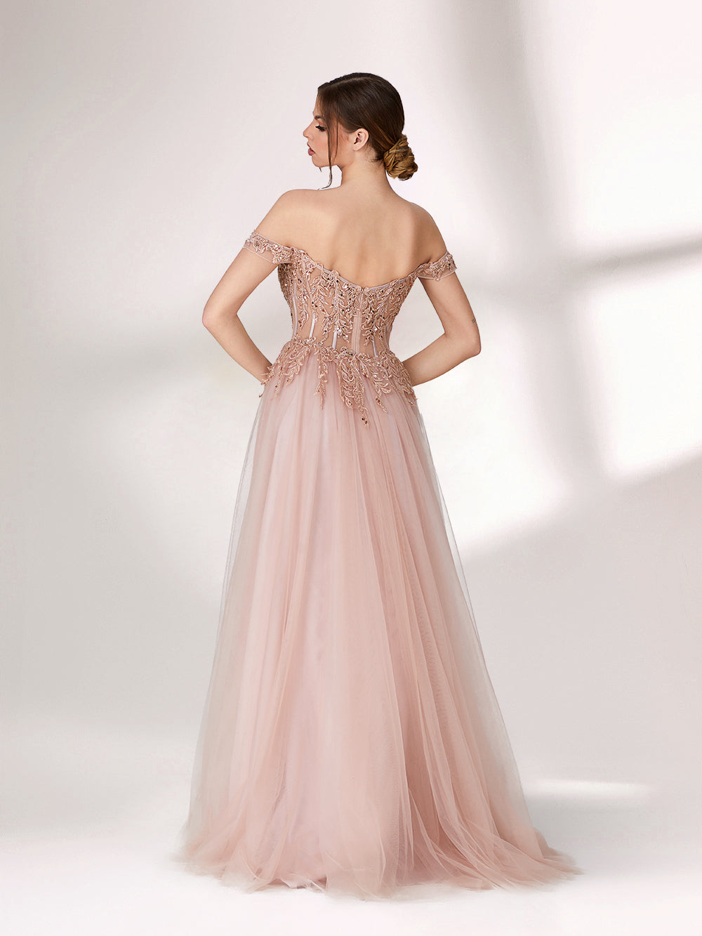 A woman stands against a light background, wearing a blush - pink evening gown. It has an off - the - shoulder design with a sweetheart neckline. The bodice is adorned with intricate lace and bead embroidery, and the skirt is made of flowing tulle, creating an elegant and romantic look, perfect for formal events.3