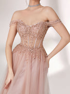 A woman stands against a light background, wearing a blush - pink evening gown. It has an off - the - shoulder design with a sweetheart neckline. The bodice is adorned with intricate lace and bead embroidery, and the skirt is made of flowing tulle, creating an elegant and romantic look, perfect for formal events.5