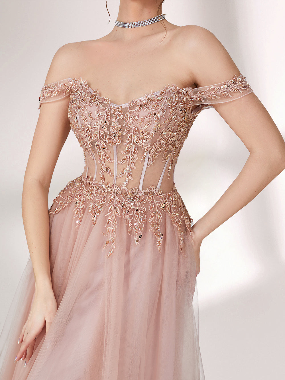 A woman stands against a light background, wearing a blush - pink evening gown. It has an off - the - shoulder design with a sweetheart neckline. The bodice is adorned with intricate lace and bead embroidery, and the skirt is made of flowing tulle, creating an elegant and romantic look, perfect for formal events.5