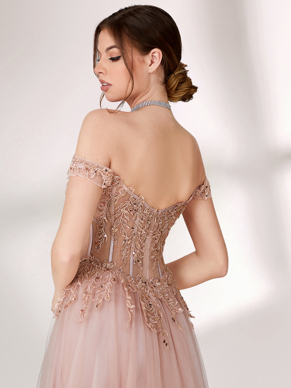 A woman stands against a light background, wearing a blush - pink evening gown. It has an off - the - shoulder design with a sweetheart neckline. The bodice is adorned with intricate lace and bead embroidery, and the skirt is made of flowing tulle, creating an elegant and romantic look, perfect for formal events.6