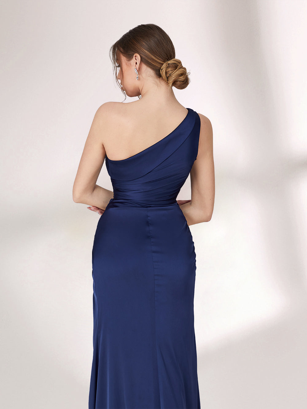 A woman stands against a light background, wearing a navy blue one - shoulder evening gown. The dress has a ruched bodice and a high side slit, creating an elegant and sexy look, perfect for formal events.3