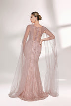 Bathed in gentle light, a woman radiates glamour in a nude - pink sequined mermaid gown. The sheer cape - like sleeves add an ethereal touch, while the body - hugging silhouette and shimmering sequins create a show - stopping, elegant look for formal events.3