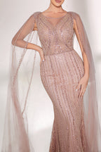 Bathed in gentle light, a woman radiates glamour in a nude - pink sequined mermaid gown. The sheer cape - like sleeves add an ethereal touch, while the body - hugging silhouette and shimmering sequins create a show - stopping, elegant look for formal events.4