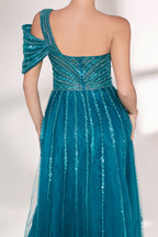 Against a light - hued backdrop, a woman dons a teal sequin gown with an one - shoulder design. It features a bow - detailed strap, a sheer waist panel, and a high side slit. The sparkling sequins and unique silhouette radiate glamour, perfect for formal dinners or galas.6