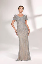 A woman stands against a light background, wearing a silver - grey beaded gown. It features off - shoulder sleeves, a V - neckline, and a mermaid silhouette. The intricate bead patterns and sheer fabric exude elegance, perfect for formal galas or weddings, radiating timeless charm.1