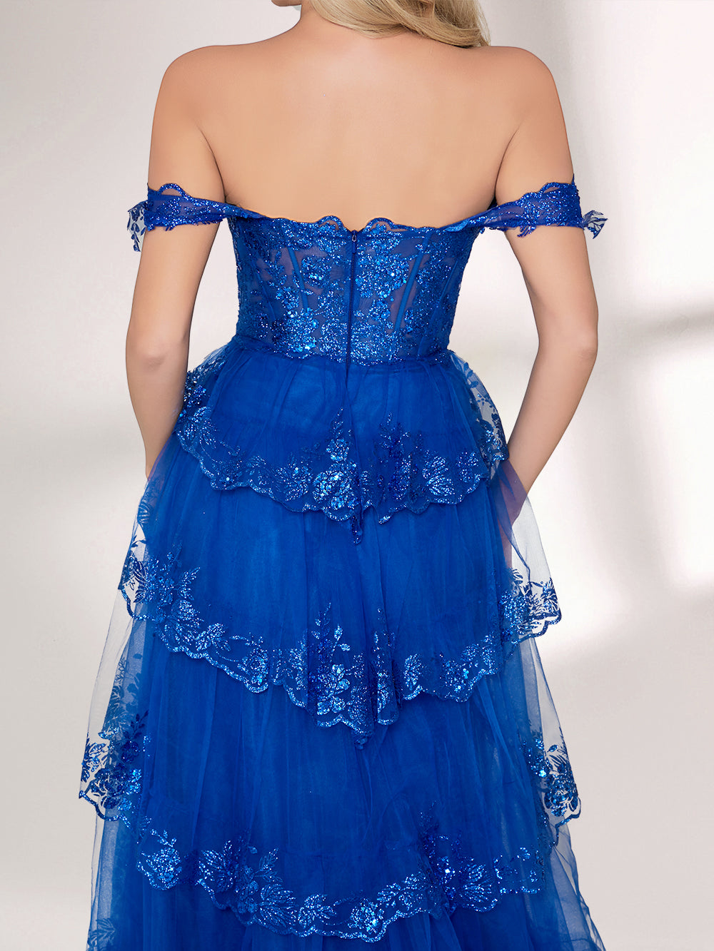A woman stands against a light background, wearing a royal - blue tulle gown with sequin embellishments. It has an off - shoulder design, a sweetheart neckline, and a tiered skirt. The sparkling sequins and flowing fabric exude romance, perfect for formal events like weddings or galas.6