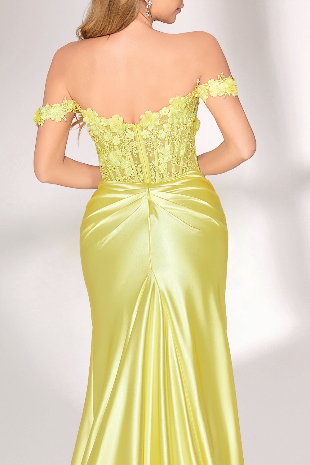 A woman with long, wavy blonde hair and a confident stance wears a bright - yellow satin gown. It has off - the - shoulder, lace - detailed sleeves, a form - fitting bodice, and a high side slit. Paired with silver heels, the outfit radiates elegance, perfect for formal events like galas or evening receptions.6