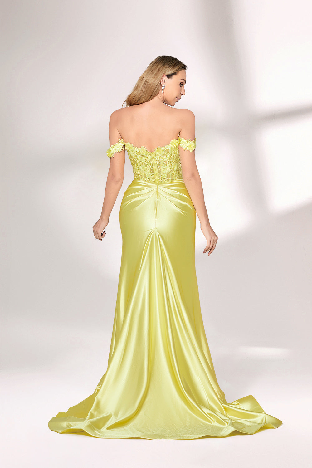 A woman with long, wavy blonde hair and a confident stance wears a bright - yellow satin gown. It has off - the - shoulder, lace - detailed sleeves, a form - fitting bodice, and a high side slit. Paired with silver heels, the outfit radiates elegance, perfect for formal events like galas or evening receptions.2