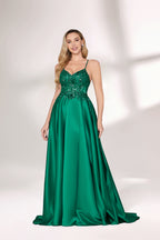 A woman with long, wavy blonde hair and a confident pose wears a rich green satin gown. It features thin spaghetti straps, a beaded and sequined bodice, and a high side slit. Paired with silver heels, the outfit radiates elegance, ideal for formal events like galas or evening receptions.06