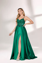 A woman with long, wavy blonde hair and a confident pose wears a rich green satin gown. It features thin spaghetti straps, a beaded and sequined bodice, and a high side slit. Paired with silver heels, the outfit radiates elegance, ideal for formal events like galas or evening receptions.01