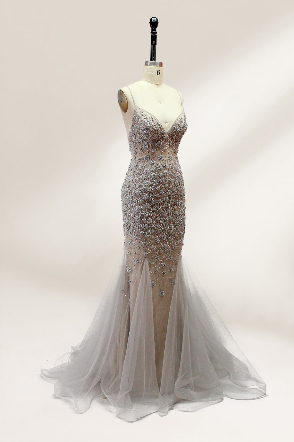 Displayed on a mannequin is a silver - gray mermaid - style gown. It features thin straps, a sweetheart neckline, intricate bead and sequin embroidery throughout, and a flowing tulle skirt. The elegant design creates a glamorous look, perfect for formal events like proms or weddings.3