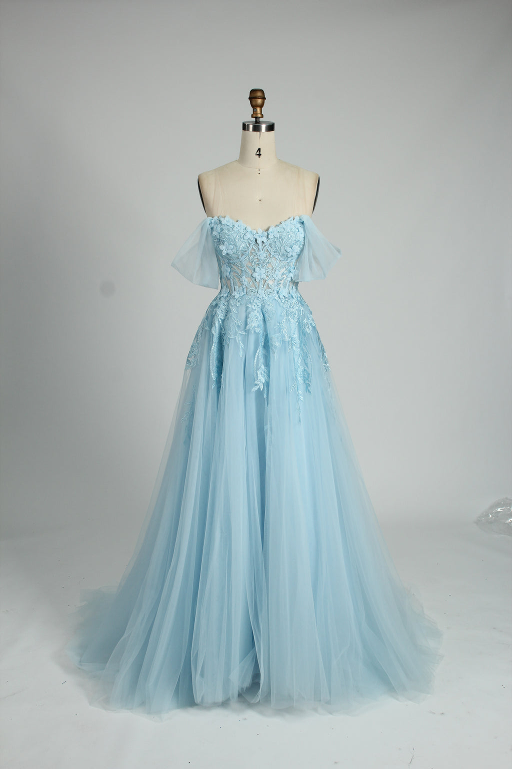 photograph of beautiful woman, elegant off-shoulder green gown, intricate lace details, long flowing tulle skirt, dark curly hair, red lipstick, hands on hips, neutral background, soft lighting, full body shot, fashion photography, classic style, sophisticated, glamorous, high-end fashion, detailed embroidery, smooth fabric texture, poised stance, serene expression, elegant atmosphere.32485c-1b-09