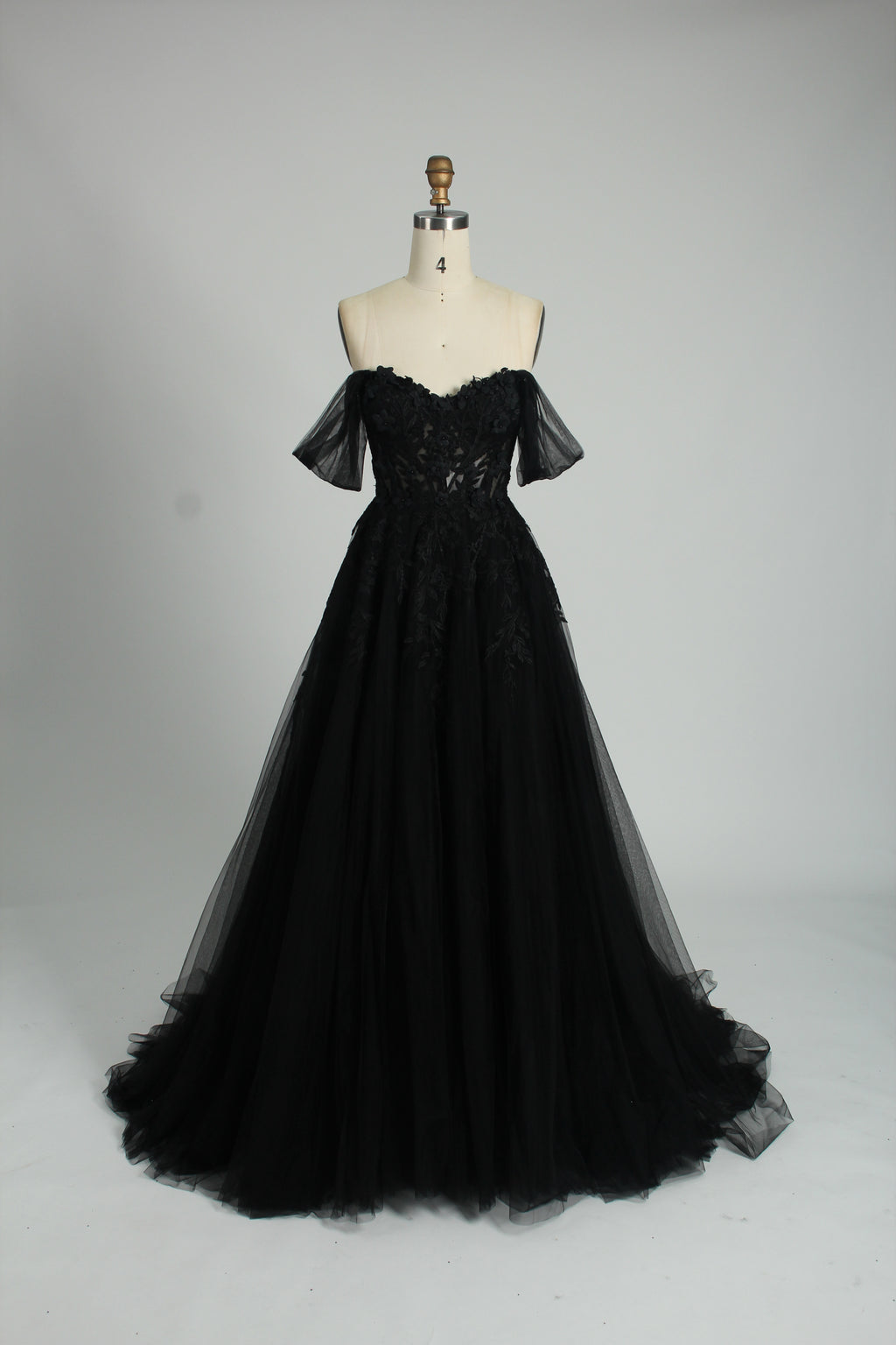 photograph of beautiful woman, elegant off-shoulder green gown, intricate lace details, long flowing tulle skirt, dark curly hair, red lipstick, hands on hips, neutral background, soft lighting, full body shot, fashion photography, classic style, sophisticated, glamorous, high-end fashion, detailed embroidery, smooth fabric texture, poised stance, serene expression, elegant atmosphere.32485c-1b-10