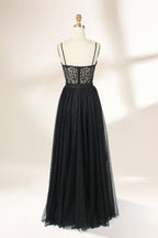 Photograph of a black, lace-trimmed, strapless gown with a sweetheart neckline and a full, flowing tulle skirt. The dress is displayed on a white mannequin with a wooden stand against a plain, light beige background, creating a simple and elegant setting.32547c-2.2