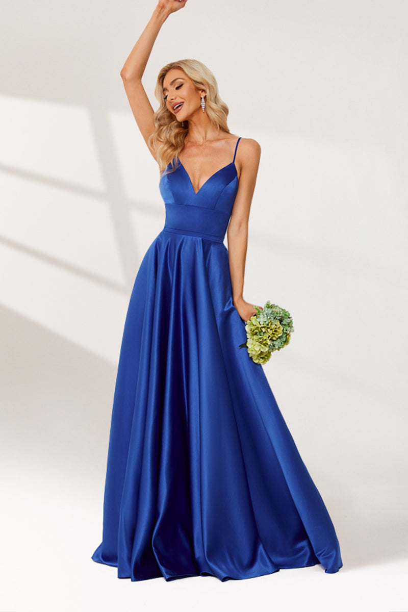 photograph of a beautiful blonde woman in a floor-length, deep blue satin gown, elegant dress with a plunging neckline and spaghetti straps, holding a bouquet of flowers in her left hand, standing confidently with one arm raised, wavy hair, white background, soft lighting, high-fashion, bridal attire, full-body shot, studio setting, minimalistic background, glamorous, sophisticated, bridal fashion, formal wear.32636-01