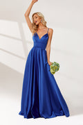 photograph of a beautiful blonde woman in a floor-length, deep blue satin gown, elegant dress with a plunging neckline and spaghetti straps, holding a bouquet of flowers in her left hand, standing confidently with one arm raised, wavy hair, white background, soft lighting, high-fashion, bridal attire, full-body shot, studio setting, minimalistic background, glamorous, sophisticated, bridal fashion, formal wear.32636-01