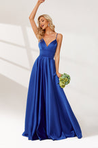 photograph of a beautiful blonde woman in a floor-length, deep blue satin gown, elegant dress with a plunging neckline and spaghetti straps, holding a bouquet of flowers in her left hand, standing confidently with one arm raised, wavy hair, white background, soft lighting, high-fashion, bridal attire, full-body shot, studio setting, minimalistic background, glamorous, sophisticated, bridal fashion, formal wear.32636-01
