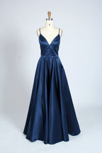 photograph, beautiful woman, long blonde hair, wavy hair, fair skin, blue satin gown, floor-length dress, V-neck, sleeveless, elegant, standing pose, white background, studio lighting, shadows on wall, confident expression, red lipstick, glamorous, high-fashion, evening wear, full body shot, no accessories, simple backdrop, clean lines, minimalistic, modern style, fashionable, chic, sophisticated, elegant, high-quality image, sharp details.32636-12