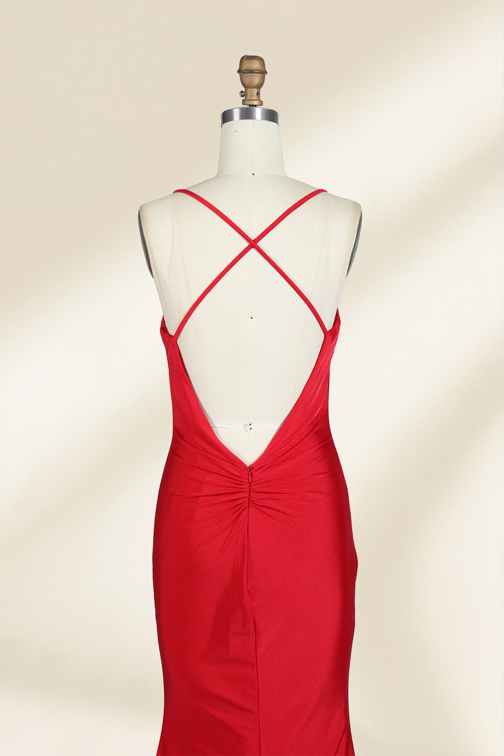 A photograph of a red, floor-length, strapless evening gown displayed on a white dress form with a wooden neck and arm rods. The gown has a fitted bodice and a flowing, slightly flared skirt. The background is a plain, light beige, emphasizing the dress's vibrant color and elegant design.32637.6