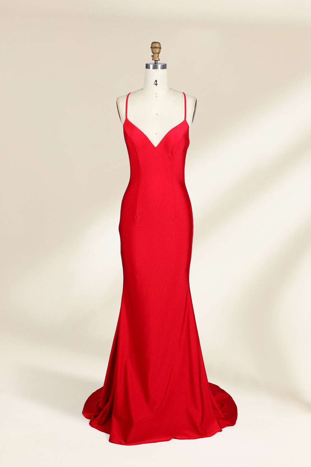A photograph of a red, floor-length, strapless evening gown displayed on a white dress form with a wooden neck and arm rods. The gown has a fitted bodice and a flowing, slightly flared skirt. The background is a plain, light beige, emphasizing the dress's vibrant color and elegant design.32637_1