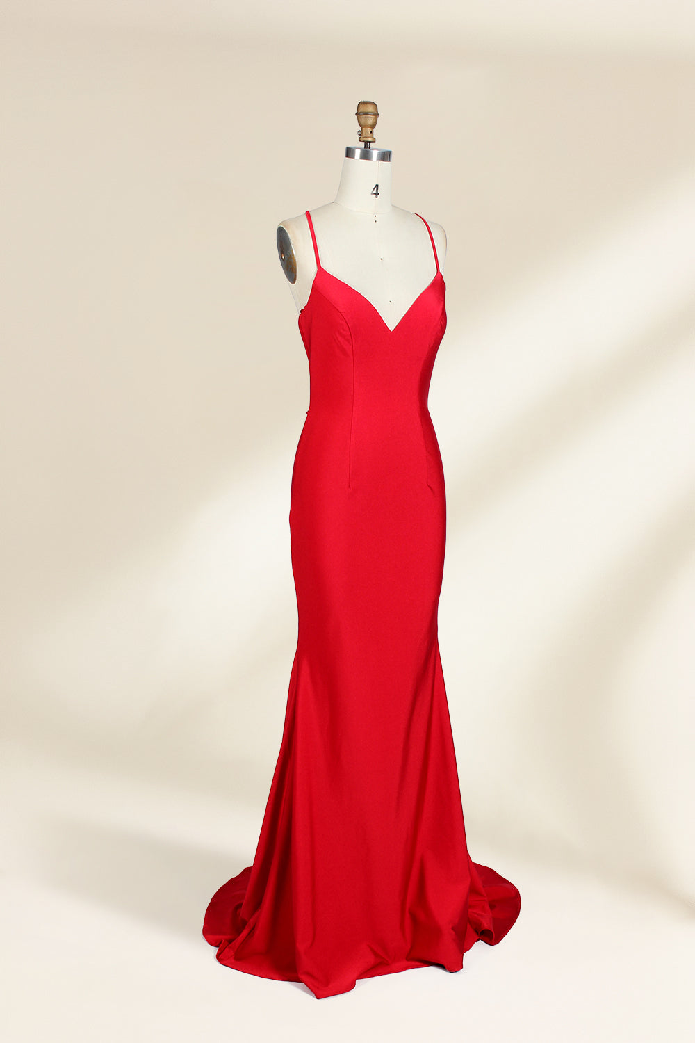 A photograph of a red, floor-length, strapless evening gown displayed on a white dress form with a wooden neck and arm rods. The gown has a fitted bodice and a flowing, slightly flared skirt. The background is a plain, light beige, emphasizing the dress's vibrant color and elegant design.32637_2