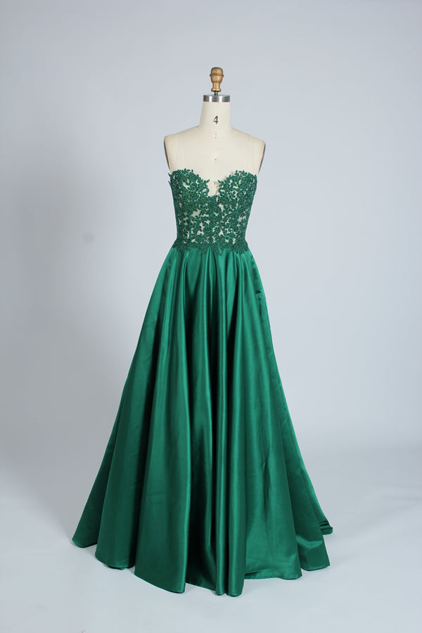 Photograph of an elegant, strapless gown displayed on a mannequin. The gown features a green, satin bodice adorned with intricate lace detailing and a full, floor-length skirt. The background is a soft, neutral gradient, enhancing the gown's vibrant green color. The mannequin is positioned centrally, with the gown's luxurious texture and refined craftsmanship prominently showcased.32639_9