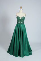 Photograph of an elegant, strapless gown displayed on a mannequin. The gown features a green, satin bodice adorned with intricate lace detailing and a full, floor-length skirt. The background is a soft, neutral gradient, enhancing the gown's vibrant green color. The mannequin is positioned centrally, with the gown's luxurious texture and refined craftsmanship prominently showcased.32639_9
