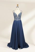 Photograph of a mannequin showcasing an elegant, floor-length evening gown. The gown features a deep V-neckline adorned with intricate blue floral embroidery, transitioning into a flowing, dark blue chiffon skirt. The mannequin stands against a plain, cream-colored backdrop. The dress exudes sophistication and luxury, perfect for formal events.01