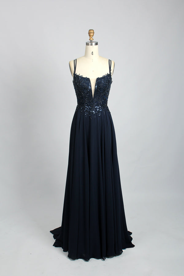 photograph, elegant evening gown, dark navy blue, fitted bodice with intricate beadwork, plunging V-neckline, spaghetti straps, flowing floor-length skirt, mannequin model, wooden stand, plain white background, studio lighting, fashion photography, simple and classy, no accessories, no jewelry, no shoes, sophisticated and glamorous, high-end fashion, modern design, formal wear, full-length dress, no visible seams, smooth fabric, luxurious and elegant, stylish and chic.