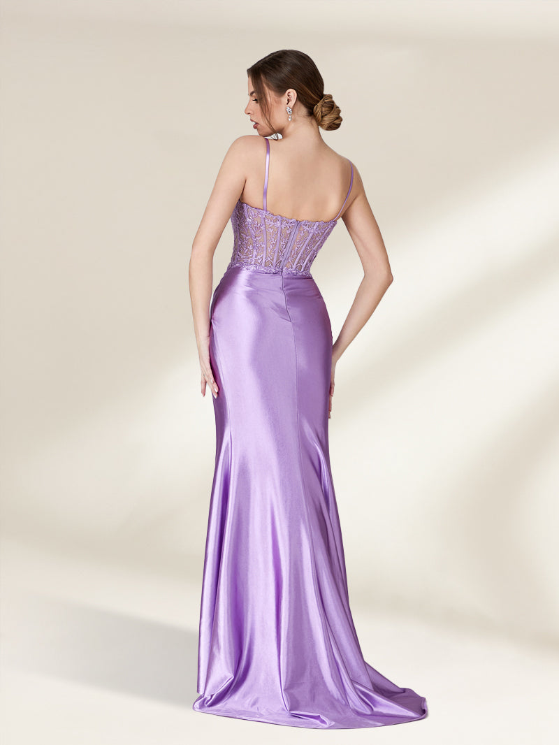 Photograph of a slender, light-skinned woman with brunette hair in a bun, wearing a strapless, lavender satin gown with intricate lace detailing on the back. The gown has a fitted bodice and a flowing, floor-length skirt. She stands against a plain, cream-colored background, with soft shadows adding depth. The gown's texture appears smooth and luxurious. The overall aesthetic is elegant and sophisticated.32738-02