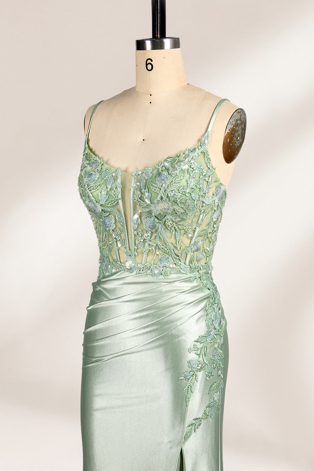 photograph of elegant floor-length evening gown, pastel mint green color, lace bodice with intricate floral patterns, fitted bodice with sweetheart neckline, high slit on right side, smooth satin fabric, model mannequin with neutral expression, studio setting, soft natural lighting, beige background, fashion photography, no accessories, focus on dress details, no people, simple and classy, high-end fashion, luxury, sophistication.33020-02