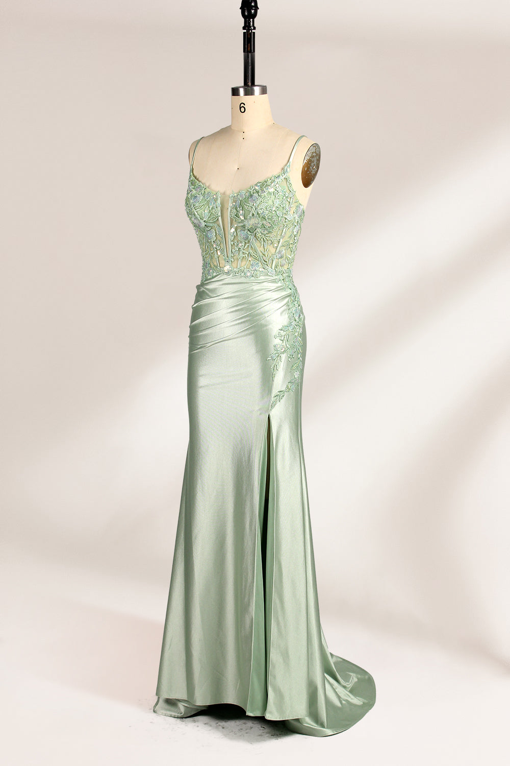 photograph of elegant floor-length evening gown, pastel mint green color, lace bodice with intricate floral patterns, fitted bodice with sweetheart neckline, high slit on right side, smooth satin fabric, model mannequin with neutral expression, studio setting, soft natural lighting, beige background, fashion photography, no accessories, focus on dress details, no people, simple and classy, high-end fashion, luxury, sophistication.33020-04