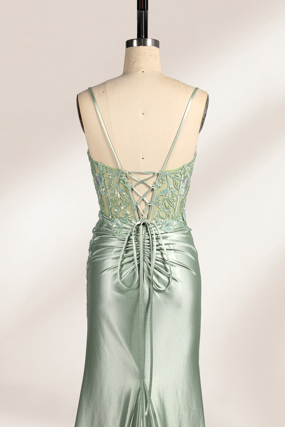 photograph of elegant floor-length evening gown, pastel mint green color, lace bodice with intricate floral patterns, fitted bodice with sweetheart neckline, high slit on right side, smooth satin fabric, model mannequin with neutral expression, studio setting, soft natural lighting, beige background, fashion photography, no accessories, focus on dress details, no people, simple and classy, high-end fashion, luxury, sophistication.33020-06