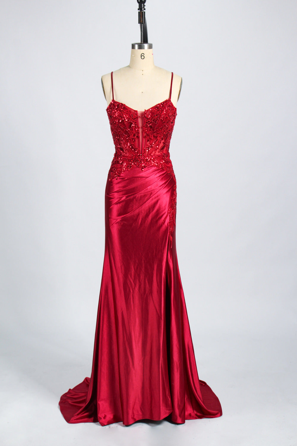 photograph of a beautiful woman wearing a stunning royal blue evening gown with a thigh-high slit, intricate lace detailing on the bodice, elegant design, long sleeves, slim fit, standing in a studio with soft lighting, white background, delicate jewelry, dark hair styled in a sleek updo, confident pose, graceful, sophisticated, fashion photography, high-quality, luxurious, formal attire, glamorous.33028-10