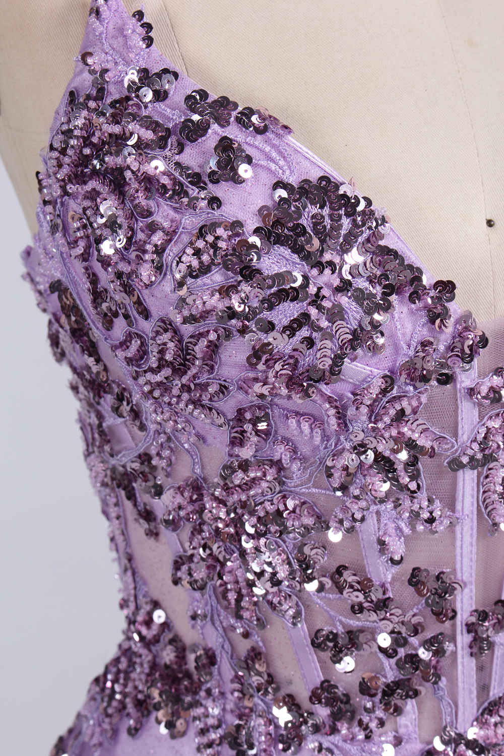 photograph of a young woman wearing a beautiful, floor-length, lavender ball gown with intricate sequin detailing on the bodice, sheer tulle skirt, spaghetti straps, long brown hair, fair skin, standing in a soft lit studio, neutral background, elegant, sophisticated, dreamy, fashion, glamour, full body shot, high quality, fashion photography, stylish, feminine, graceful, classy, modern, delicate, light, airy.33040-07