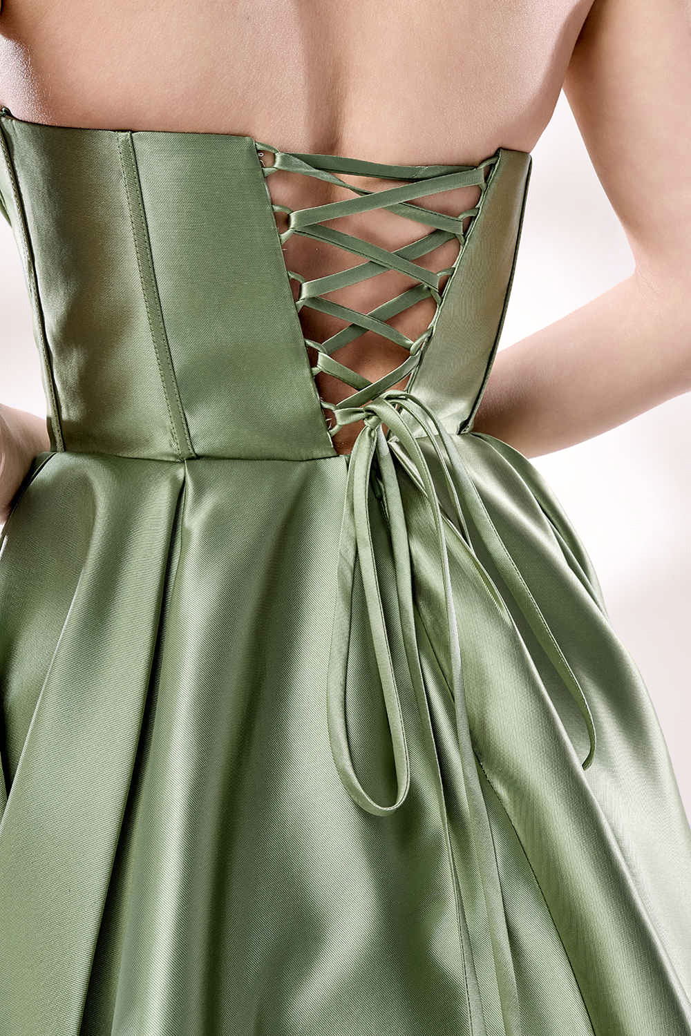 photograph of a woman in a backless, strapless, emerald green satin gown, standing against a white studio background, soft shadows, elegant, classic style, smooth fabric texture, hair in an elegant updo, long flowing gown, no visible accessories, minimalistic setting, studio lighting, elegant and sophisticated, full-length dress, high slit, backless design, full body shot, serene and graceful atmosphere.33110B-06