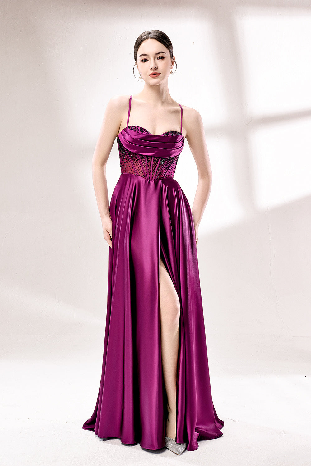 photograph, elegant woman, standing, studio lighting, white background, full-length shot, wearing a floor-length, deep purple satin gown, lace details, spaghetti straps, high slit on one side, hands on hips, brown hair in a sleek updo, red lipstick, soft shadows, minimalistic setting, fashion photography, evening wear, classy, sophisticated, stylish, modern, feminine, confident pose, high-quality image, no visible watermark.33116B-01
