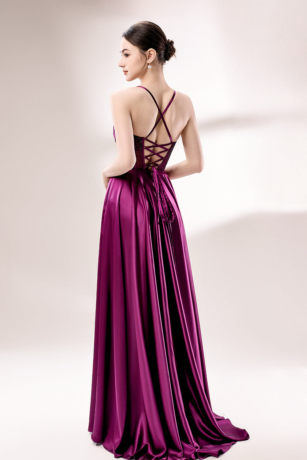 photograph, elegant woman, standing, studio lighting, white background, full-length shot, wearing a floor-length, deep purple satin gown, lace details, spaghetti straps, high slit on one side, hands on hips, brown hair in a sleek updo, red lipstick, soft shadows, minimalistic setting, fashion photography, evening wear, classy, sophisticated, stylish, modern, feminine, confident pose, high-quality image, no visible watermark.33116B-02