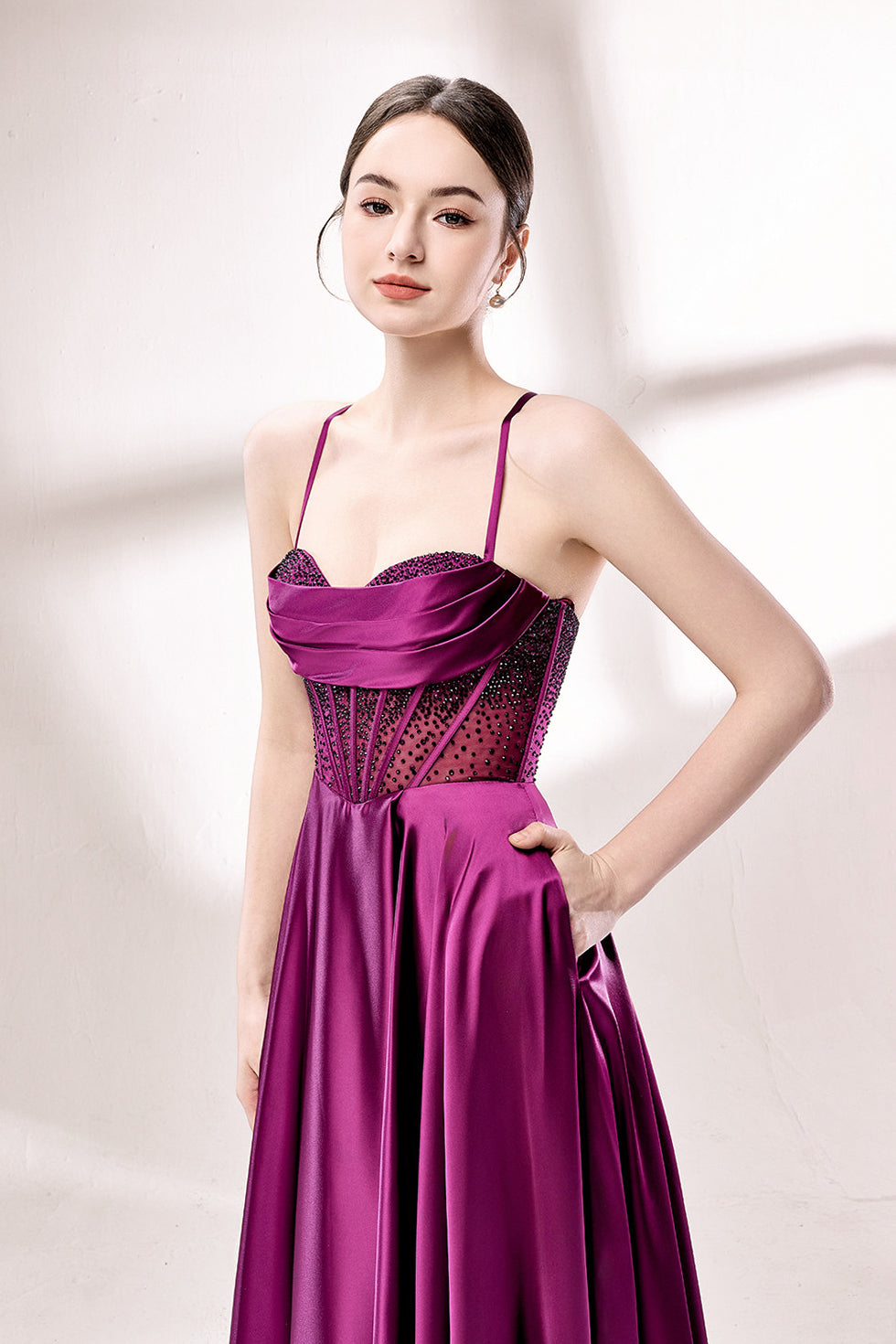 photograph, elegant woman, standing, studio lighting, white background, full-length shot, wearing a floor-length, deep purple satin gown, lace details, spaghetti straps, high slit on one side, hands on hips, brown hair in a sleek updo, red lipstick, soft shadows, minimalistic setting, fashion photography, evening wear, classy, sophisticated, stylish, modern, feminine, confident pose, high-quality image, no visible watermark.33116B-03