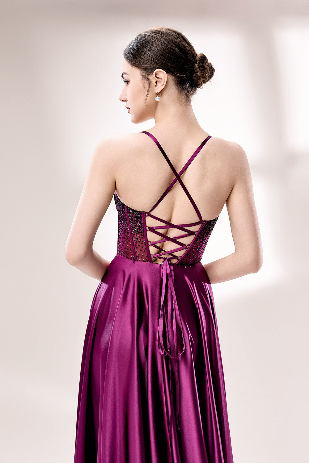 photograph, elegant woman, standing, studio lighting, white background, full-length shot, wearing a floor-length, deep purple satin gown, lace details, spaghetti straps, high slit on one side, hands on hips, brown hair in a sleek updo, red lipstick, soft shadows, minimalistic setting, fashion photography, evening wear, classy, sophisticated, stylish, modern, feminine, confident pose, high-quality image, no visible watermark.33116B-06