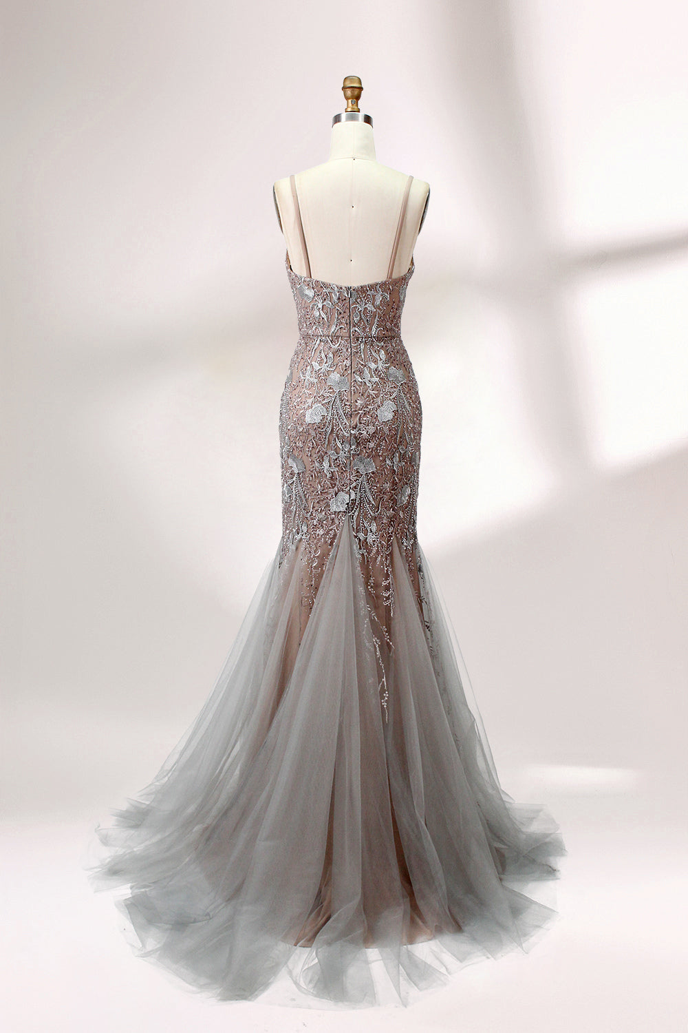 Showcased on a mannequin is a taupe - toned mermaid - cut gown. It has thin straps, a sweetheart neckline, and is embellished with delicate silver floral embroidery all over, plus a flowing tulle skirt. The refined design gives off a glamorous aura, ideal for formal events such as proms or weddings.2