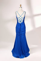 Photograph of a blue, floor-length evening gown displayed on a white dress form. The gown is sleeveless with a fitted bodice and a flared skirt, featuring thin shoulder straps and a textured, ruched design. The dress form is placed against a plain, off-white background, casting soft shadows.02