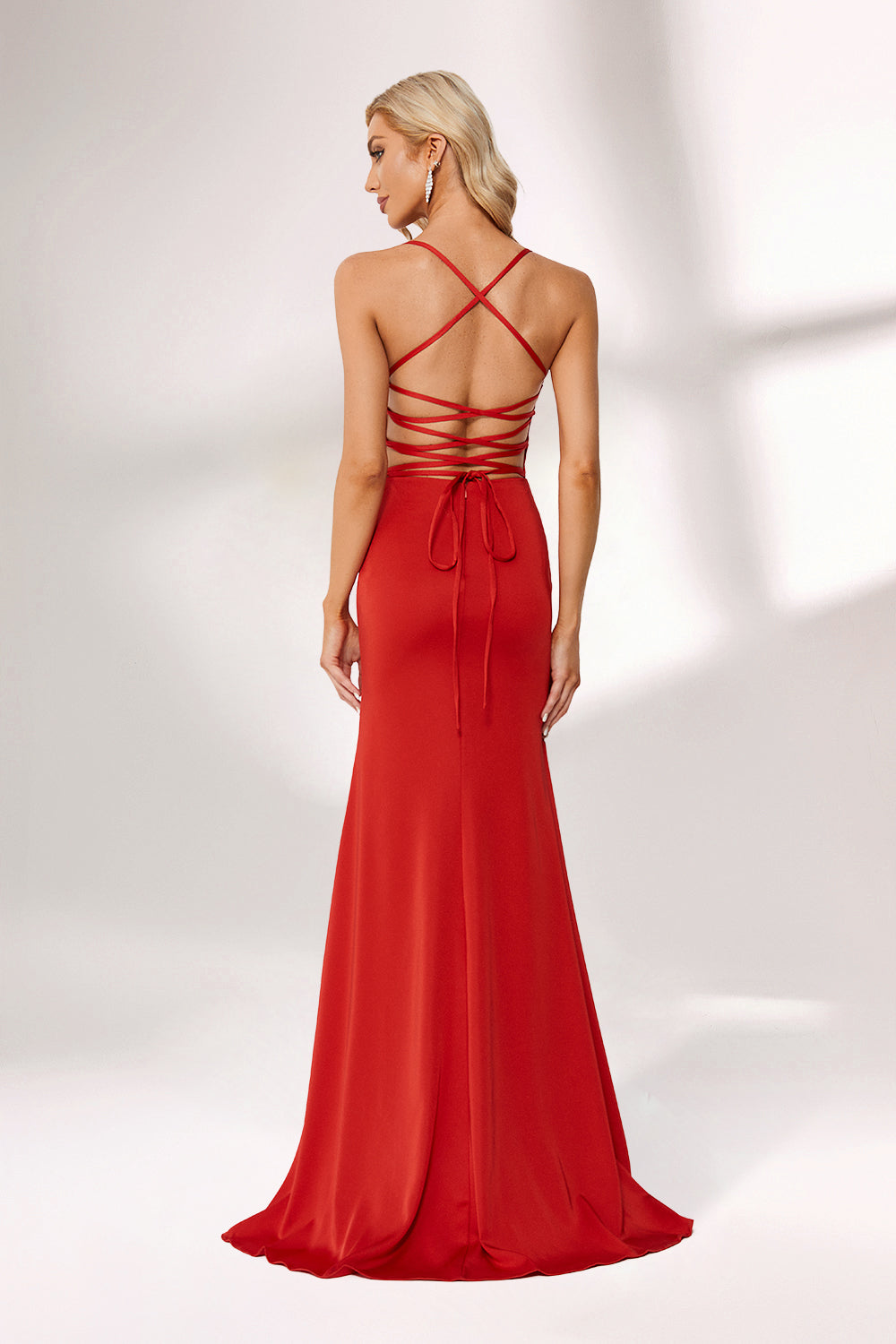 Bathed in soft light, a woman radiates charm in a red evening gown. With spaghetti straps, a deep V - neck, and a thigh - high slit, it crafts an elegant yet alluring look for formal events.2