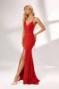 Bathed in soft light, a woman radiates charm in a red evening gown. With spaghetti straps, a deep V - neck, and a thigh - high slit, it crafts an elegant yet alluring look for formal events.1
