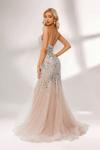 Bathed in soft light, a woman stuns in a nude - hued mermaid gown. It has thin straps, a deep V - neckline, and is covered with intricate silver geometric bead and sequin embroidery, plus a flowing tulle skirt. The shimmering details give off an opulent vibe, perfect for grand galas or red - carpet moments.5