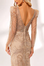 ：A woman stands against a light background, wearing a champagne - colored mermaid - style gown. It features a deep V - neckline, intricate beadwork throughout, and long sheer sleeves. The elegant design creates a glamorous and sophisticated look, perfect for formal events like galas or weddings.2