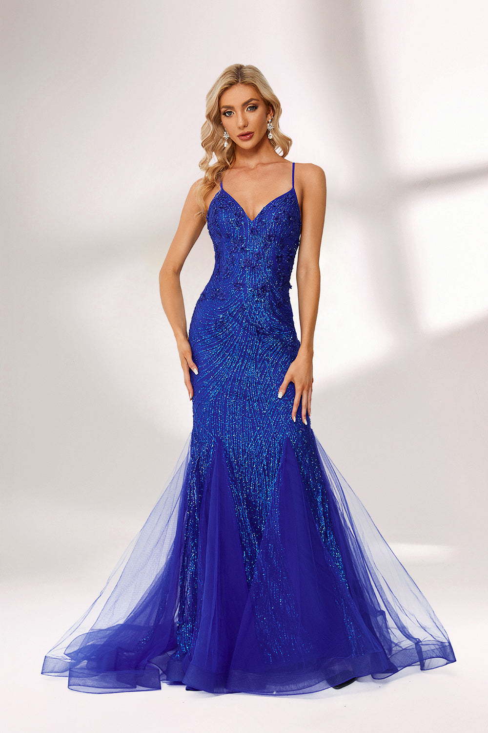 Bathed in soft light, a woman dazzles in a royal - blue sequined mermaid gown. It features thin straps, a deep V - neckline, and a flowing tulle skirt. The shimmering sequins lend an air of opulence, perfect for grand galas or red - carpet moments.3