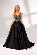 A woman stands against a light background, wearing a black satin gown. The bodice features intricate silver bead embroidery, a deep V - neckline, and thin straps. The voluminous skirt adds elegance, perfect for formal events like galas or weddings, exuding sophistication.1