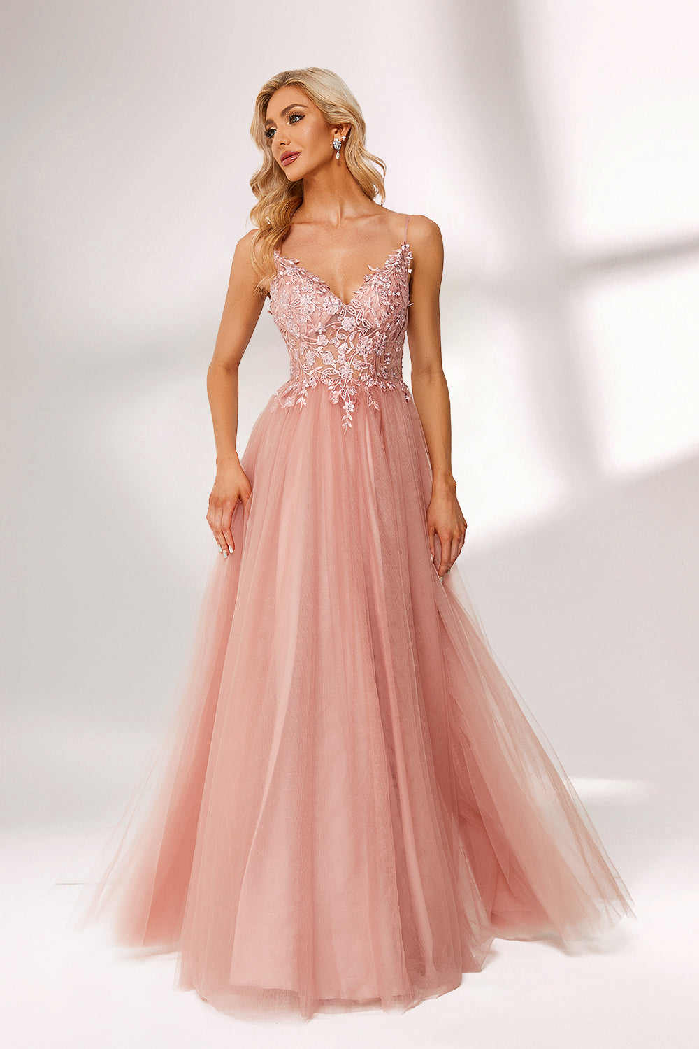 A woman stands against a light background, wearing a pink tulle gown. It has thin straps, a deep V - neckline, and a voluminous skirt. The bodice features delicate floral lace embroidery, combining romance and elegance. Perfect for formal events like weddings or proms, it exudes charm.5
