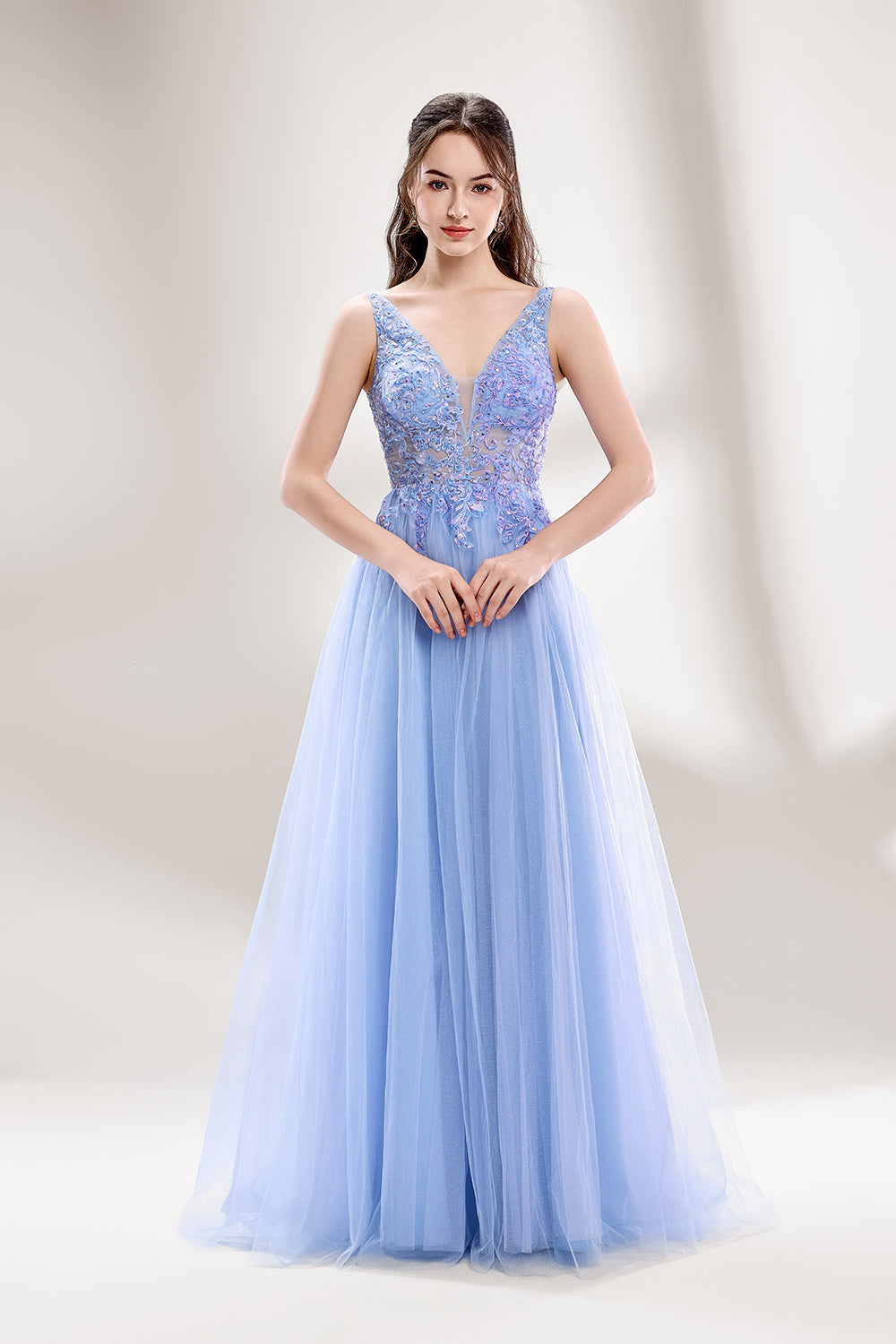 Bathed in soft light, a woman dazzles in a light blue tulle gown. It has a deep V - neckline with delicate lace embroidery on the bodice, and a flowing tulle skirt. The ethereal design creates a romantic and dreamy look, perfect for formal events like proms or weddings.3